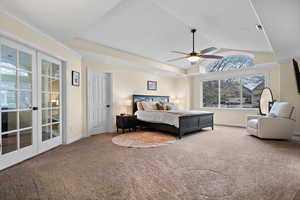 Carpeted bedroom with crown molding, lofted ceiling, ceiling fan, and french doors