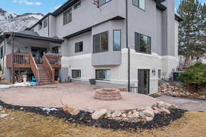 Back of house featuring a mountain view, a fire pit, and a patio area