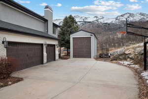 Snow covered garage featuring a mountain view