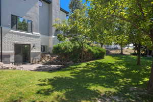 View of grassy yard featuring a patio area