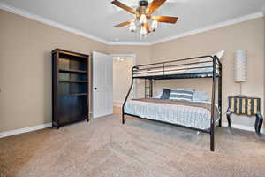 Bedroom featuring crown molding, carpet flooring, and ceiling fan