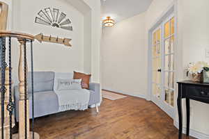 Living area with dark wood-type flooring and french doors