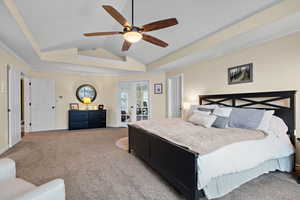 Carpeted bedroom with french doors, lofted ceiling, access to outside, ornamental molding, and ceiling fan