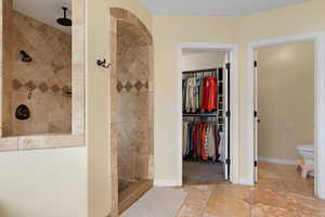 Bathroom featuring a tile shower and toilet