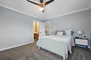 Carpeted bedroom featuring connected bathroom, crown molding, and ceiling fan