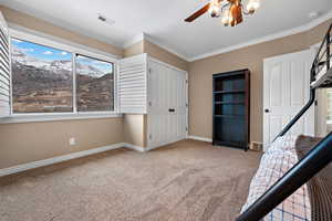 Unfurnished bedroom with ornamental molding, carpet flooring, ceiling fan, and a closet