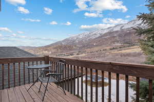 Snow covered deck featuring a mountain view