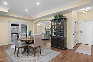 Dining space with french doors, a fireplace, ornamental molding, and dark hardwood / wood-style flooring