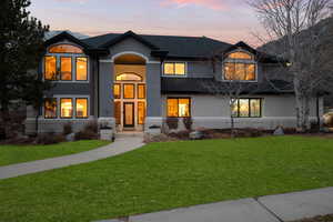 View of front of house featuring a front lawn, stucco siding, and brick siding