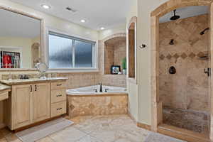 Bathroom featuring vanity and plus walk in shower