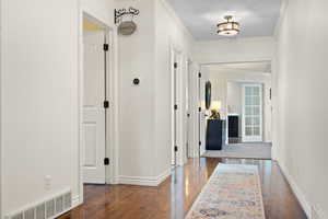 Corridor with crown molding and dark hardwood / wood-style flooring