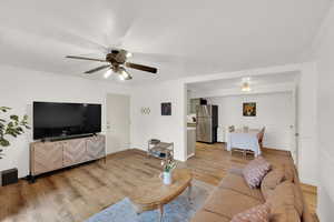 Living room featuring crown molding, light hardwood / wood-style flooring, and ceiling fan