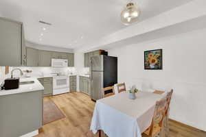 Dining space with sink and light wood-type flooring