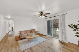 Living room with crown molding, ceiling fan, and light hardwood / wood-style flooring