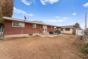 Back of house featuring a patio area and a storage unit