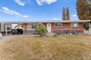 View of front of home with a front lawn and a carport