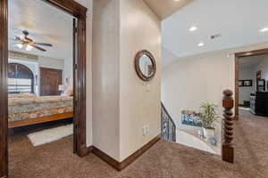 Corridor with carpet and a textured ceiling