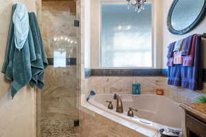 Bathroom with plus walk in shower and a notable chandelier