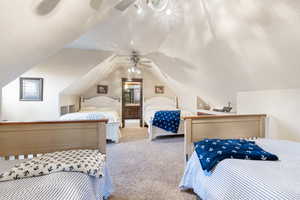 Carpeted bedroom with lofted ceiling, a textured ceiling, and ceiling fan