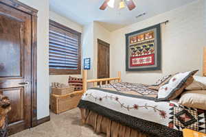 Carpeted bedroom with ceiling fan