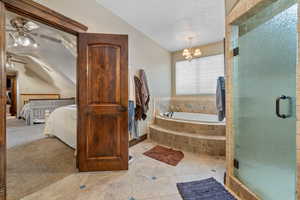 Bathroom featuring lofted ceiling, a textured ceiling, independent shower and bath, ceiling fan with notable chandelier, and tile patterned flooring