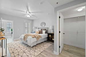 Bedroom with light hardwood / wood-style floors, a closet, and ceiling fan