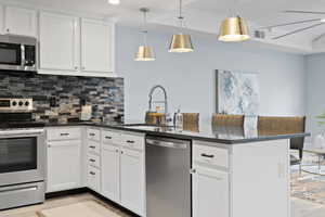 Kitchen with sink, stainless steel appliances, and white cabinets