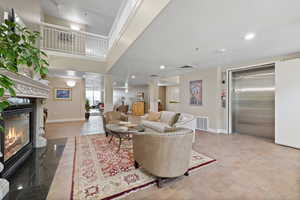 Living room with elevator, a high ceiling, and ornate columns