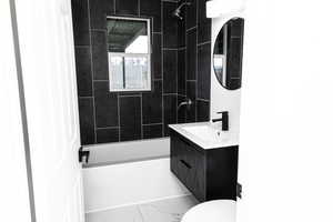 Full bathroom with vanity, toilet, and tiled shower / bath