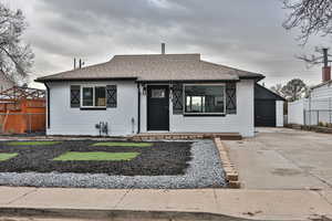 View of front of property with a garage and an outbuilding