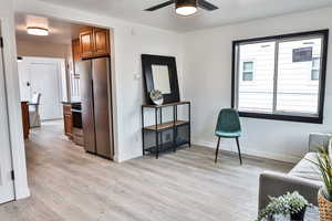 Living area with ceiling fan and light hardwood / wood-style floors