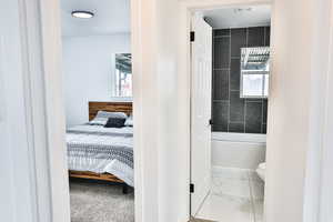 Bathroom featuring tiled shower / bath and toilet