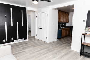 Kitchen with ceiling fan, dishwashing machine, sink, and light wood-type flooring