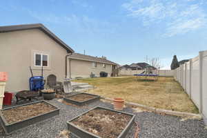 View of yard featuring central AC, a trampoline, and an outdoor fire pit