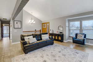 Living room with light hardwood / wood-style flooring, plenty of natural light, and lofted ceiling