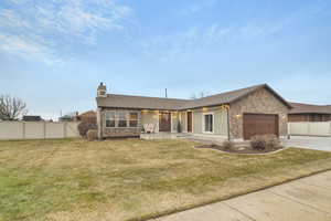 Ranch-style home featuring a garage and a front lawn