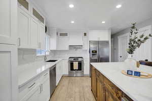 Kitchen with white cabinetry, stainless steel appliances, and sink