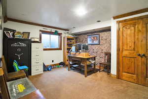 Office area with brick wall, carpet, and a textured ceiling