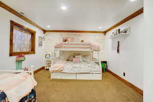 Carpeted bedroom with ornamental molding