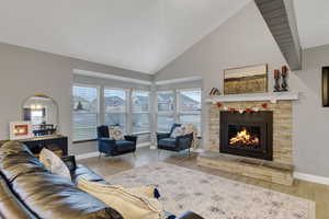 Living room with hardwood / wood-style flooring, a fireplace, and high vaulted ceiling