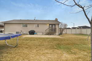 Back of house featuring a yard, central air condition unit, and a patio area