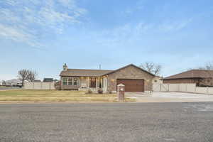 Single story home featuring a garage and a front lawn