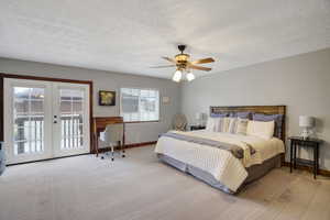 Carpeted bedroom featuring ceiling fan, access to exterior, a textured ceiling, and french doors