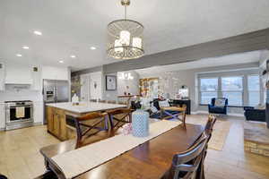 Dining area featuring a chandelier, light hardwood / wood-style flooring, and a textured ceiling