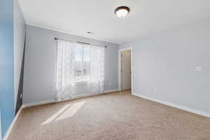 Spare room featuring baseboards, visible vents, and carpet