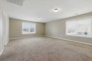 Unfurnished room featuring baseboards, carpet floors, and visible vents