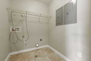 Washroom featuring hookup for an electric dryer, washer hookup, baseboards, laundry area, and electric panel