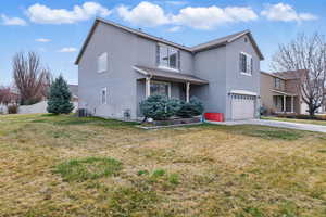 Traditional-style house with concrete driveway, fence, a front yard, central AC, and a garage