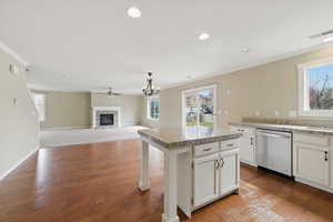 Kitchen with visible vents, ornamental molding, dishwasher, and a glass covered fireplace