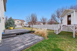 View of yard with a wooden deck and fence